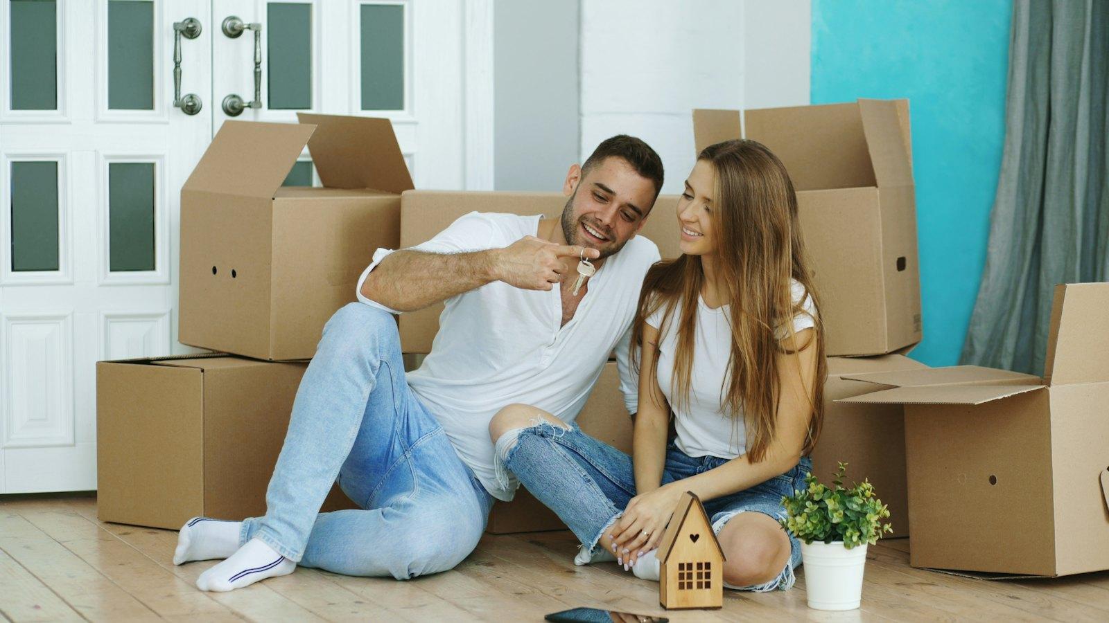 Couple sitting among moving boxes in their new home