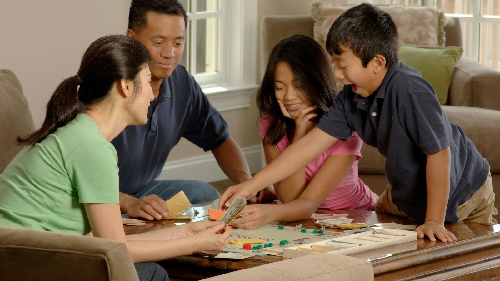 Parents and children playing a board game in the living room