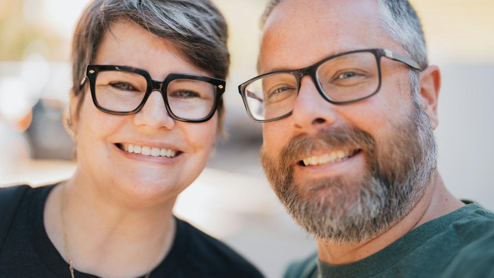 Smiling couple in their fifties wearing glasses