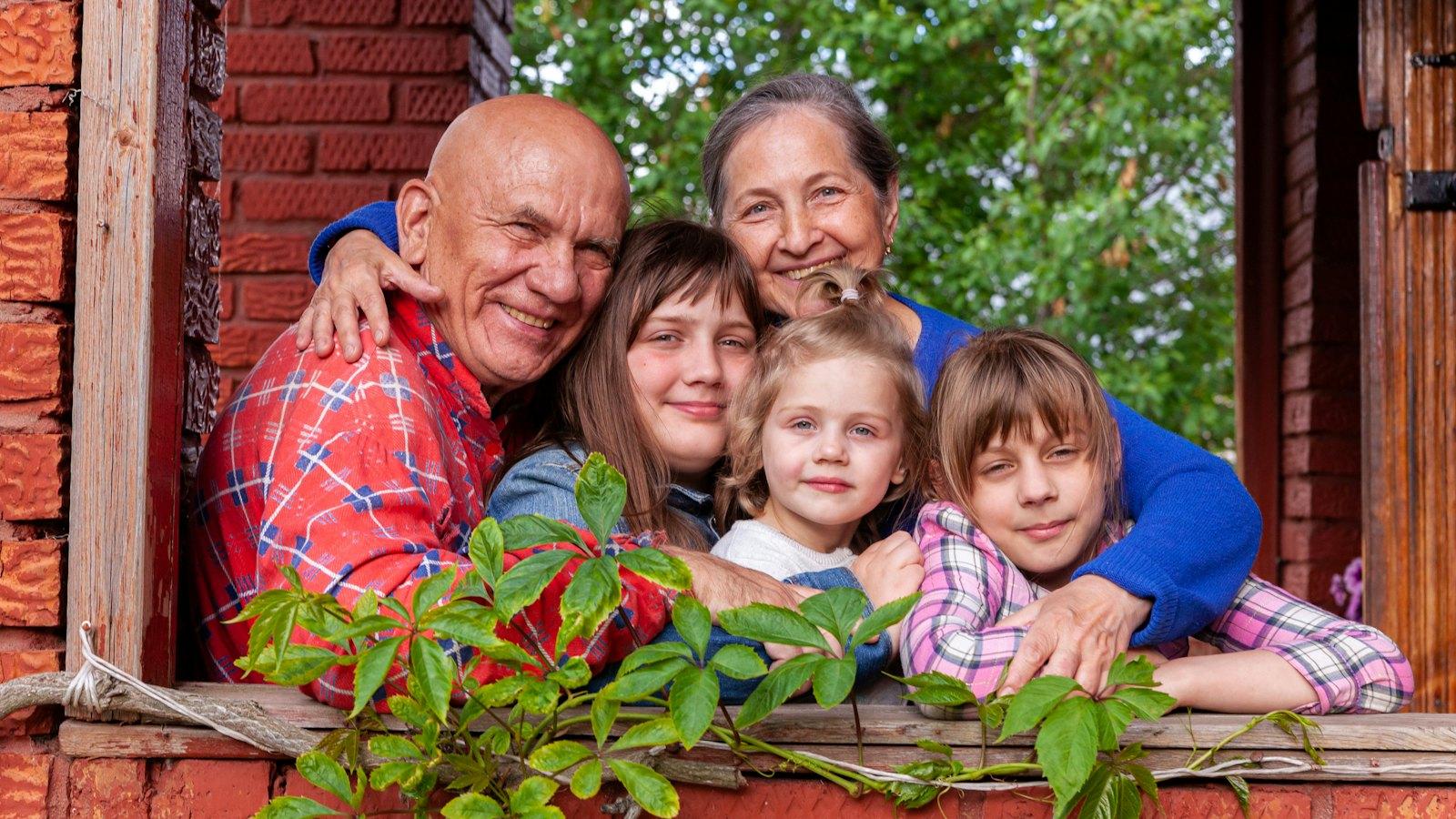Grandparents with their family looking out of a window frame