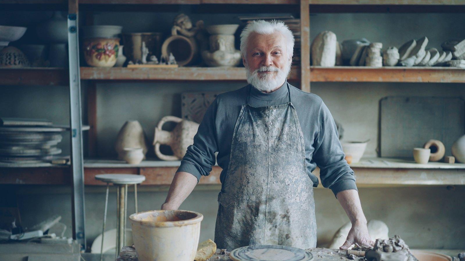Smiling older man in his pottery workshop