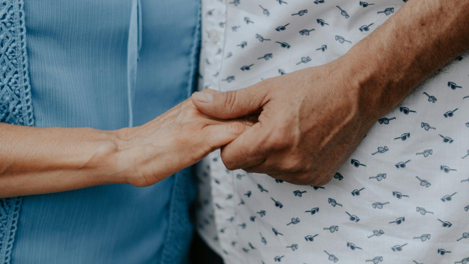 Close-up of two people holding hands