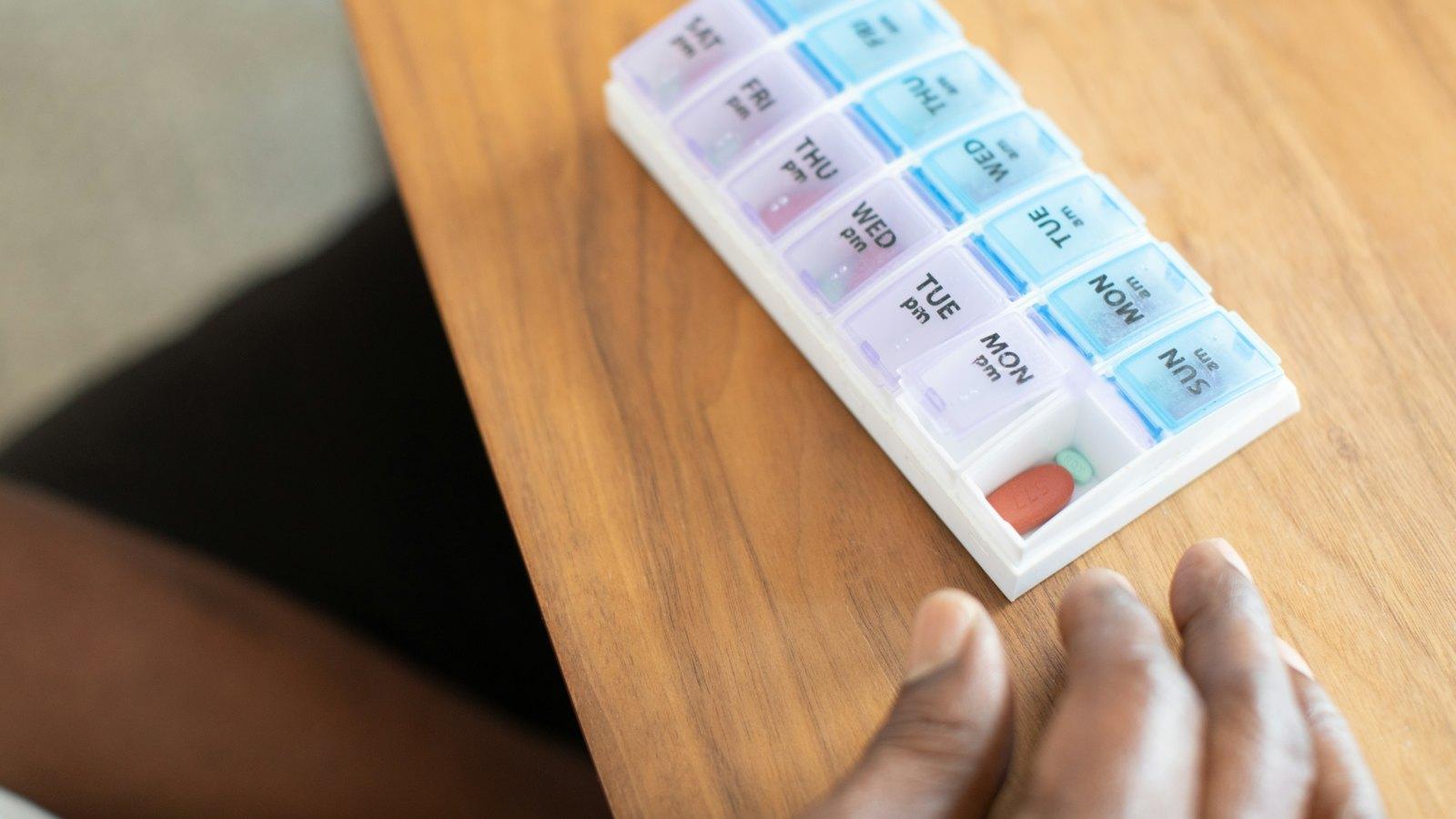 Weekly pill organizer on a wooden table