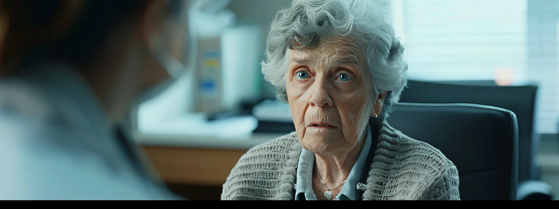 a senior sitting in a doctor's office, with a concerned expression, listening intently during a consultation about medicare coverage.