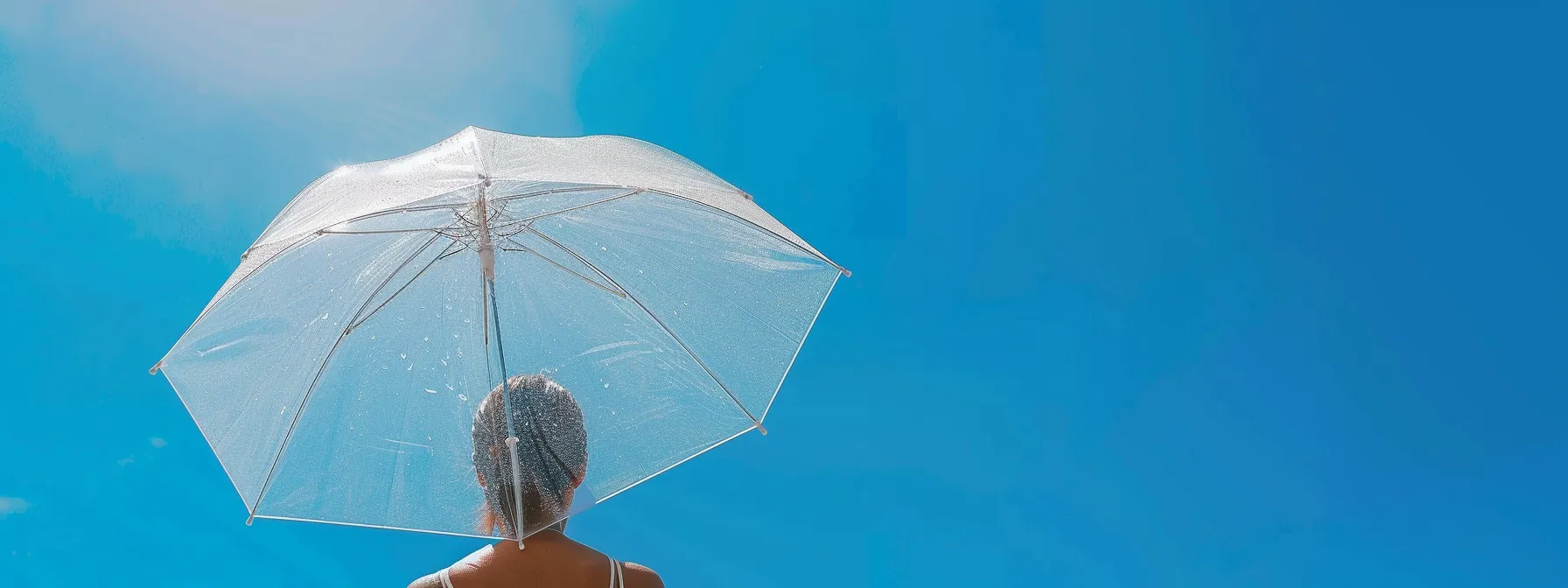  an individual confidently holding a transparent umbrella under a clear blue sky, symbolizing clarity and protection in understanding annuities.