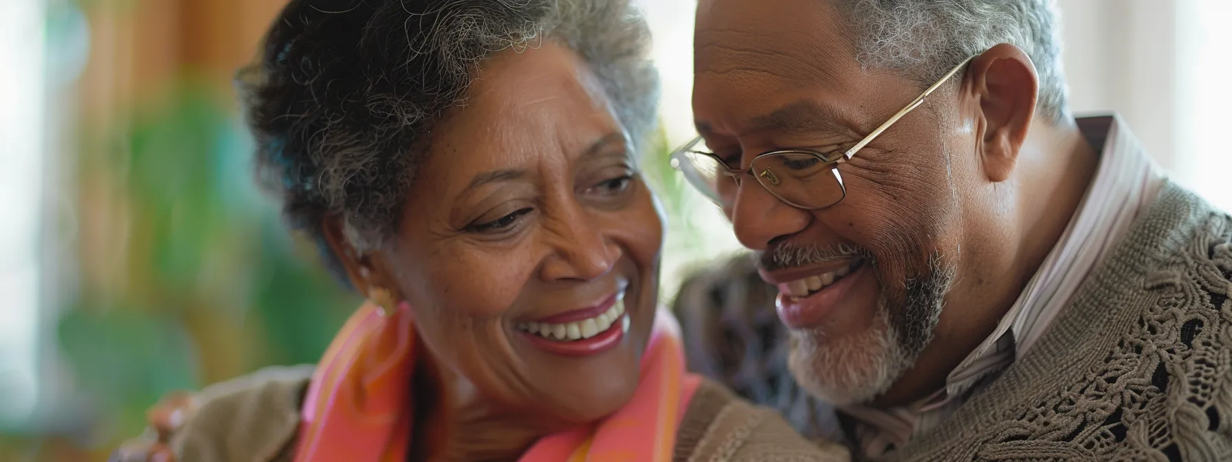 a senior couple smiling as they review different final expense insurance policies with a financial advisor.